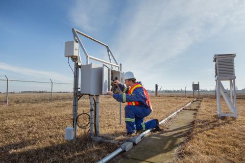 Employee inspects instrumentation in safety gear