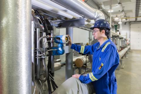 guy checks metre on pipeline