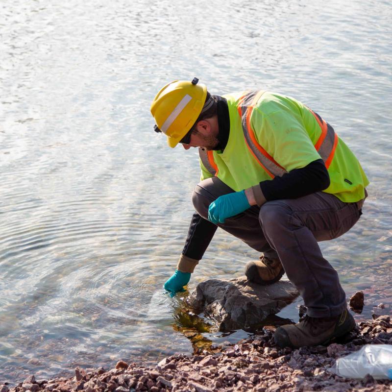 src remediation specialist dips container in water to sample