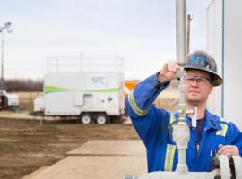 engineer fits pipe at well site